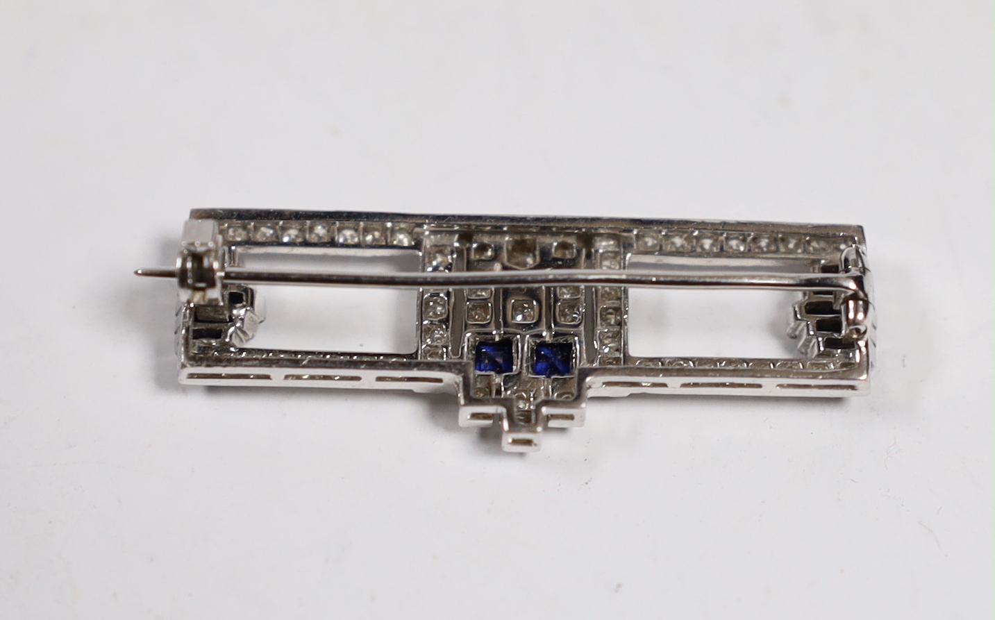 A 1980's Art Deco style Garrard 18ct white gold, sapphire and diamond cluster set bar brooch, 35mm, gross weight 4.4 grams.